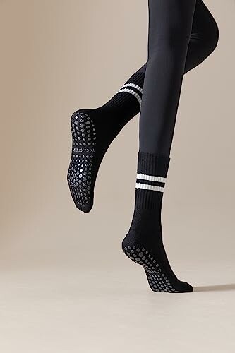Person wearing black grip socks with white stripes