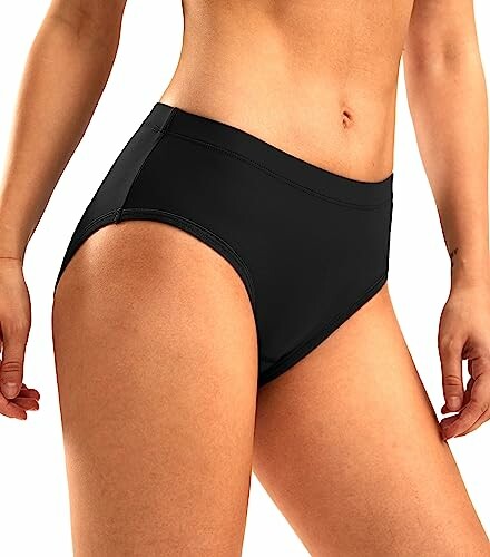 Woman wearing black high-waisted bikini bottom