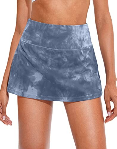 Woman wearing a blue tie-dye athletic skirt.