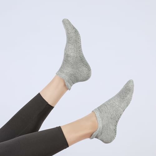Person wearing gray socks on raised legs