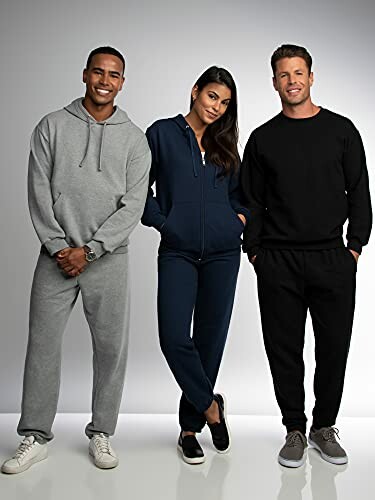 Three people in casual sweatsuits standing together.