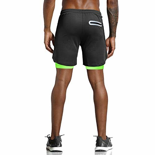 Man wearing black and green sports shorts from the back.