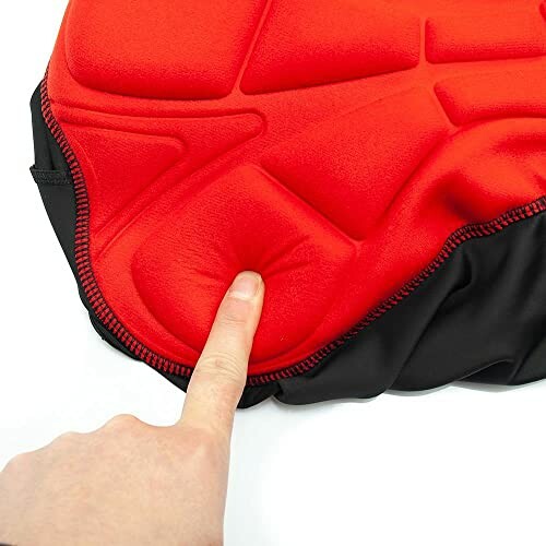 Finger pressing red cycling seat cushion pad.