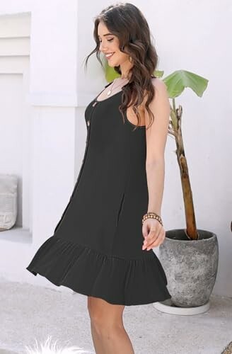 Woman in black dress standing outdoors.