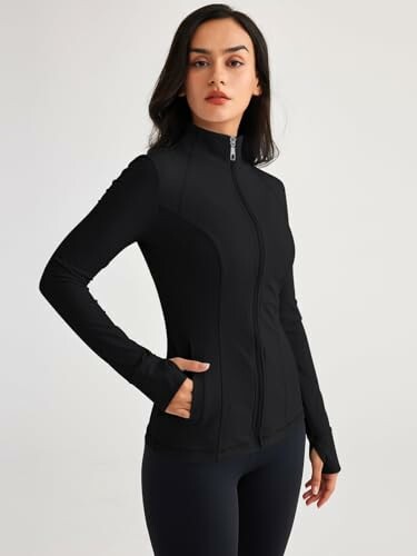 Woman wearing a black zip-up jacket with pockets