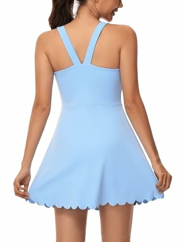 Woman wearing a light blue dress, viewed from the back.