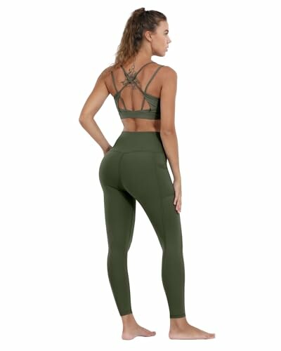 Woman wearing green activewear set with crisscross back design.