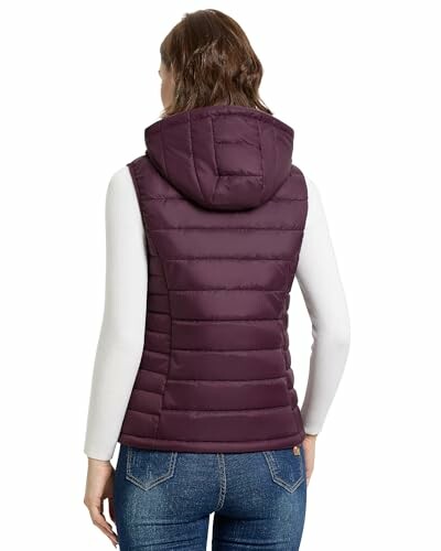 Woman in purple puffer vest with hood, back view