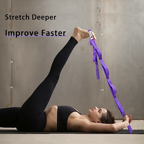 Woman using a purple yoga strap for leg stretching.